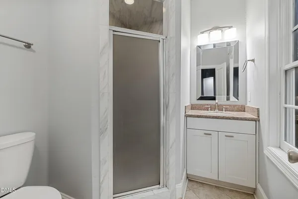 a bathroom with a toilet a sink and mirror