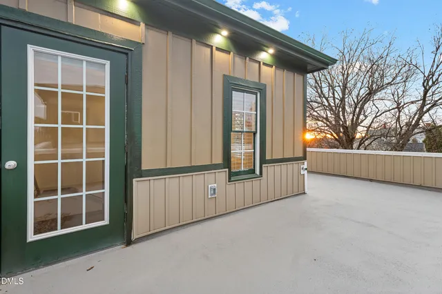 a view of an empty room with a window and wooden walls