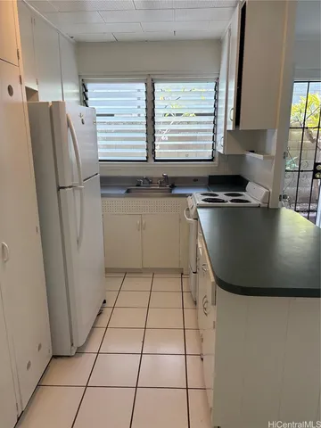 a kitchen with a sink a refrigerator and window