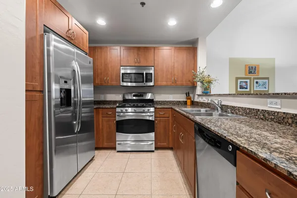 a kitchen with stainless steel appliances granite countertop a stove microwave and refrigerator