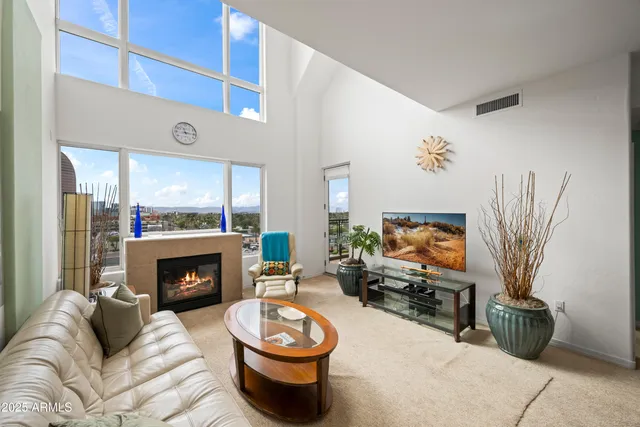 a living room with furniture a flat screen tv and a fireplace