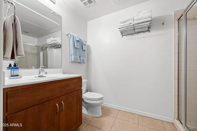 a bathroom with a sink a toilet a mirror and shower