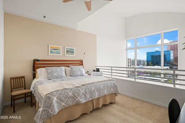 a bedroom with a bed and a large window
