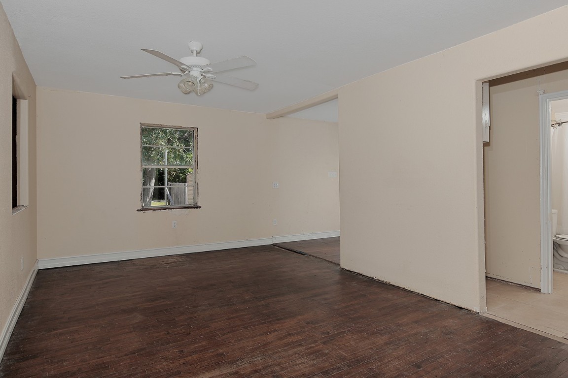 1231 Pruitt Road Spring, TX 77380 - Photo 13 of 37 an empty room with wooden floor chandelier fan and windows