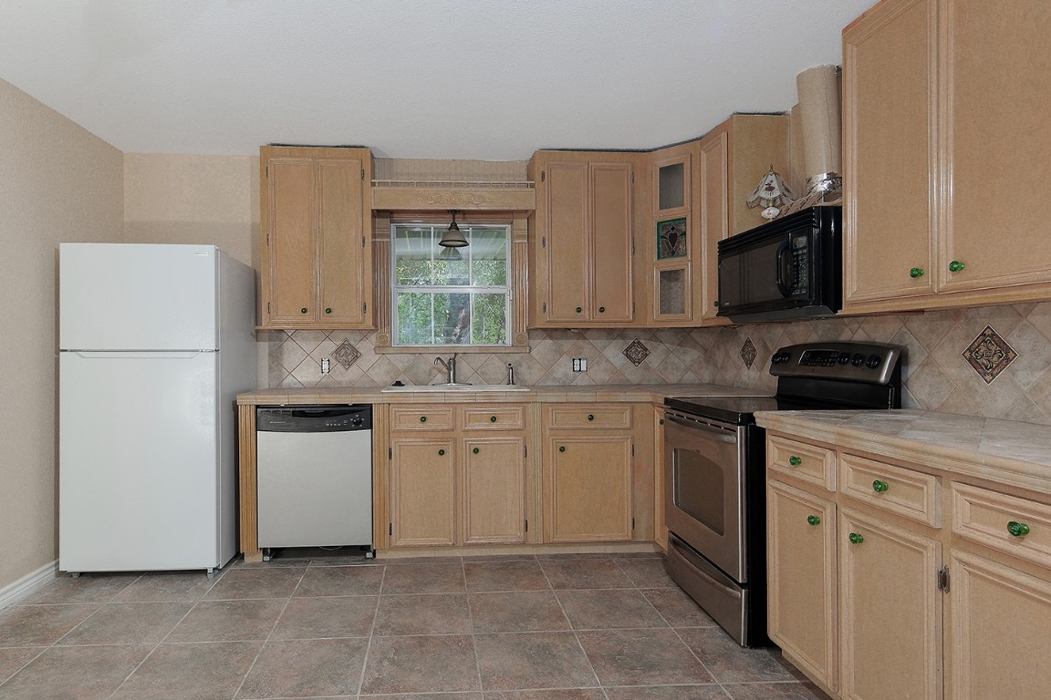 1231 Pruitt Road Spring, TX 77380 - Photo 18 of 37 a kitchen with white cabinets and white appliances