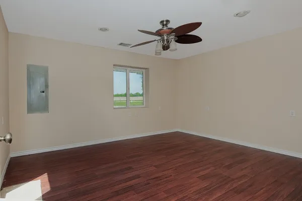 a view of a big room with wooden floor and windows