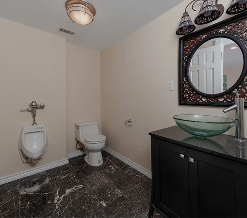 a bathroom with a toilet a sink and a mirror