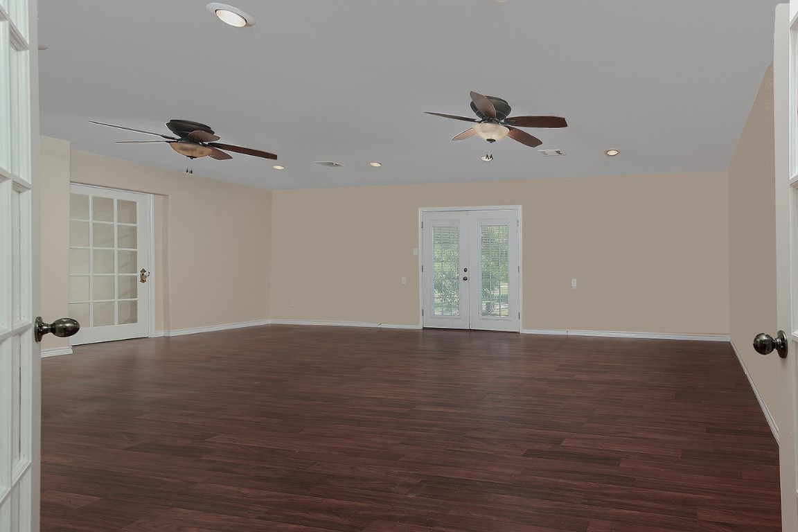 1231 Pruitt Road Spring, TX 77380 - Photo 25 of 37 an empty room with wooden floor ceiling fan and windows