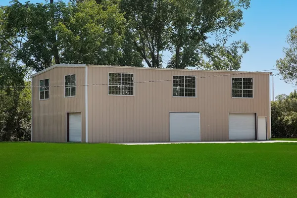 a front view of house with yard and trees in the background