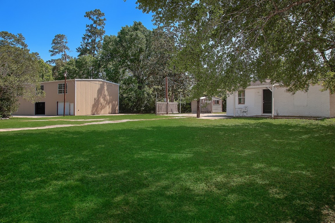 1231 Pruitt Road Spring, TX 77380 - Photo 10 of 37 a front view of a house with a yard and trees