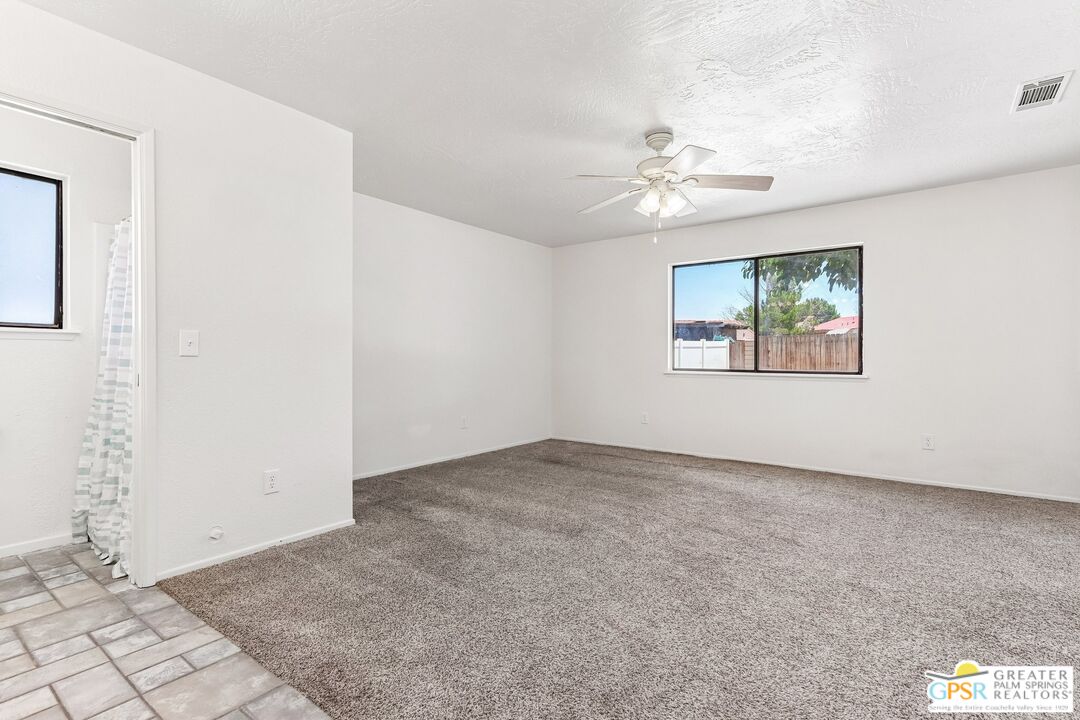 13819 Rivers Edge Road Helendale, CA 92342 - Photo 12 of 31 an empty room with windows and fan