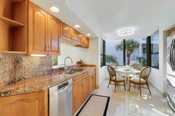 a kitchen with stainless steel appliances granite countertop sink stove and cabinets