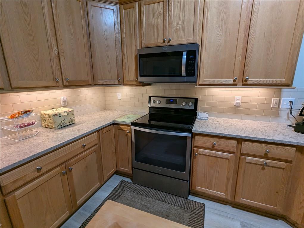 3204 Tudor Drive Butler, PA 16001 - Photo 11 of 35 a kitchen with granite countertop cabinets stainless steel appliances and wooden floor