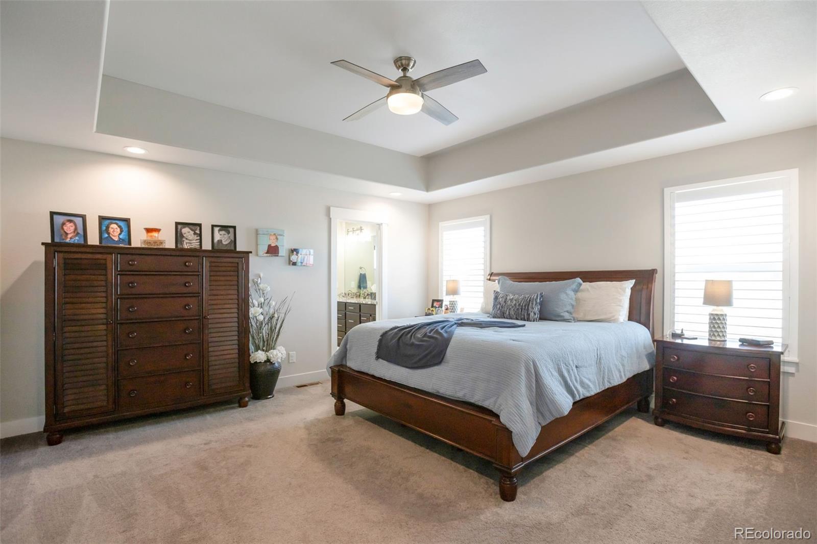 3711 Harrier Hawk Road Dacono, CO 80514 - Photo 16 of 40 a bedroom with a bed and a ceiling fan