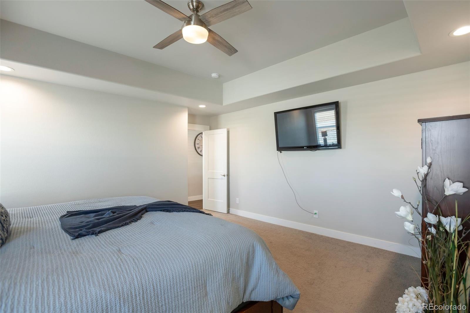 3711 Harrier Hawk Road Dacono, CO 80514 - Photo 18 of 40 a bedroom with a bed and a potted plant