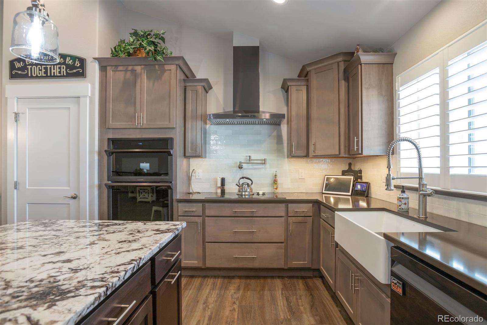 3711 Harrier Hawk Road Dacono, CO 80514 - Photo 7 of 40 a kitchen with stainless steel appliances granite countertop a sink stove and refrigerator