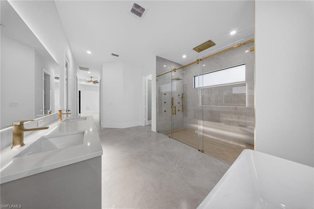 522 17th Street Southwest Naples, FL 34117 - Photo 31 of 50 a bathroom with a granite countertop sink mirror bathtub and shower