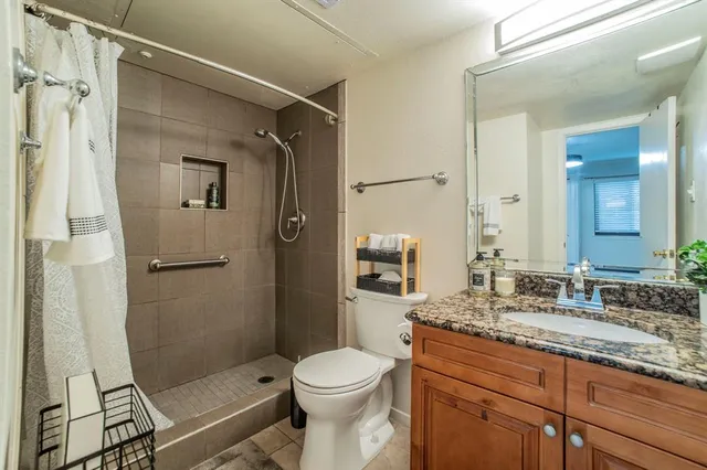 a bathroom with a granite countertop sink toilet and shower