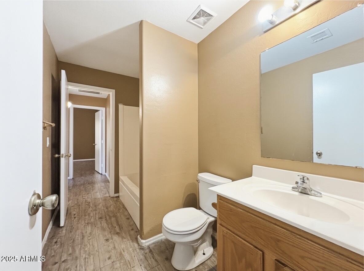 2330 West Maldonado Road Phoenix, AZ 85041 - Photo 8 of 17 a bathroom with a granite countertop toilet a sink and a mirror