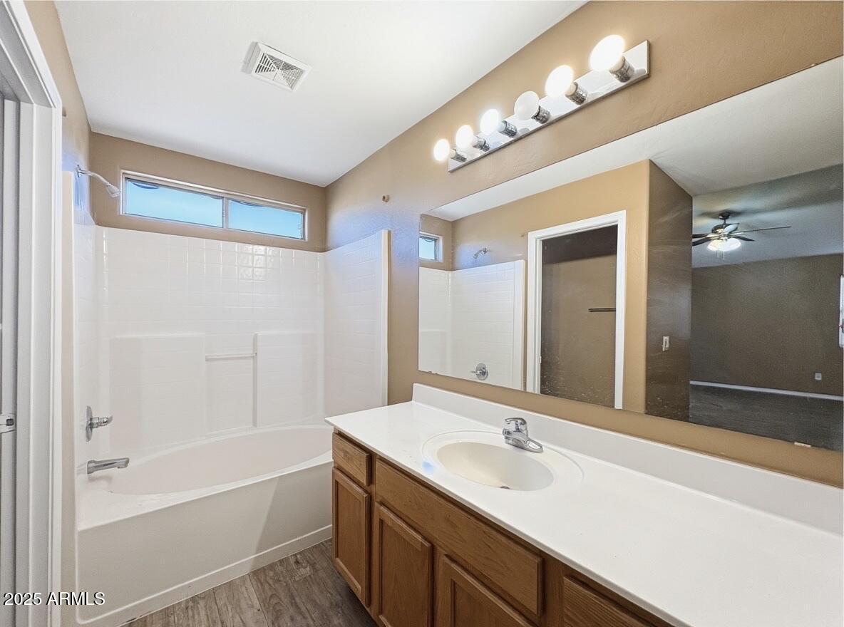 2330 West Maldonado Road Phoenix, AZ 85041 - Photo 9 of 17 a bathroom with a tub a double vanity sink and a mirror