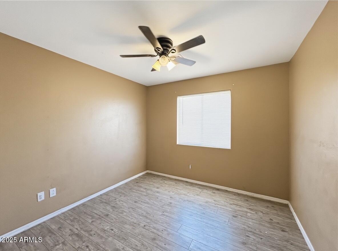 2330 West Maldonado Road Phoenix, AZ 85041 - Photo 10 of 17 wooden floor in an empty room with a window