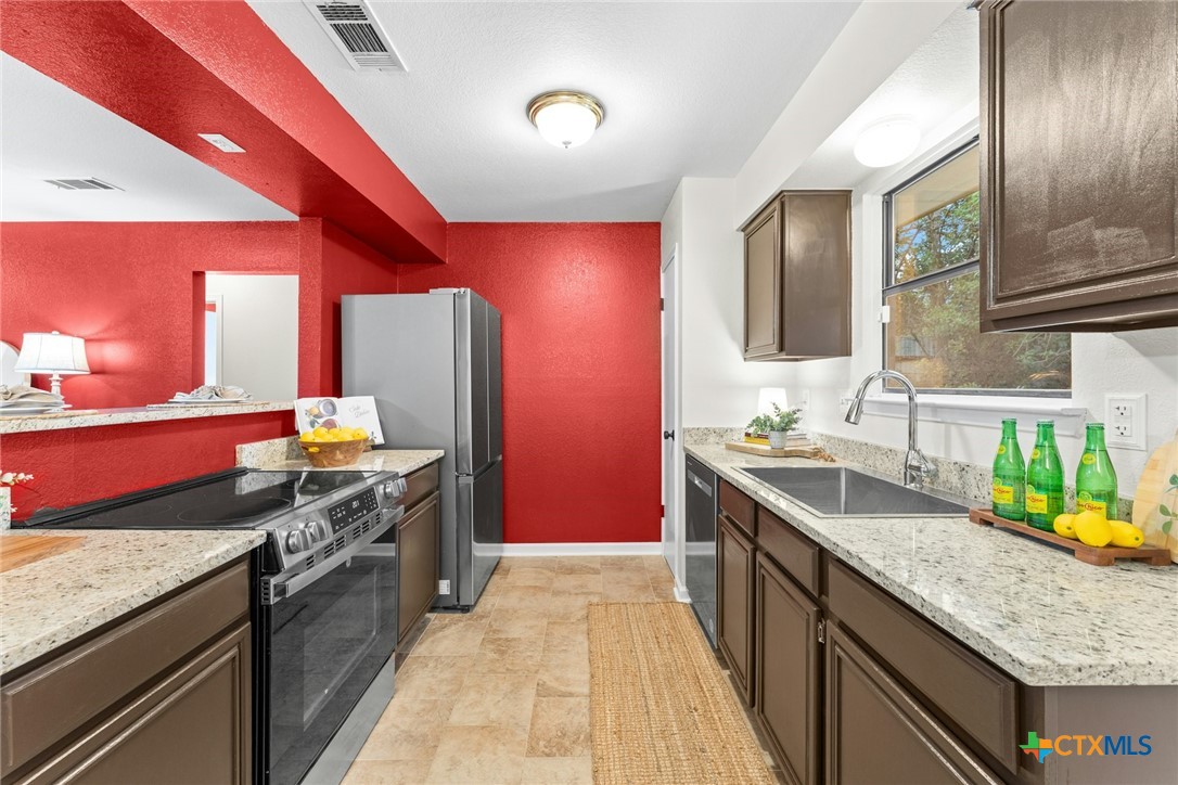 2504 Lazy Ridge Drive Killeen, TX 76543 - Photo 12 of 27 a kitchen with stainless steel appliances granite countertop a sink and stove
