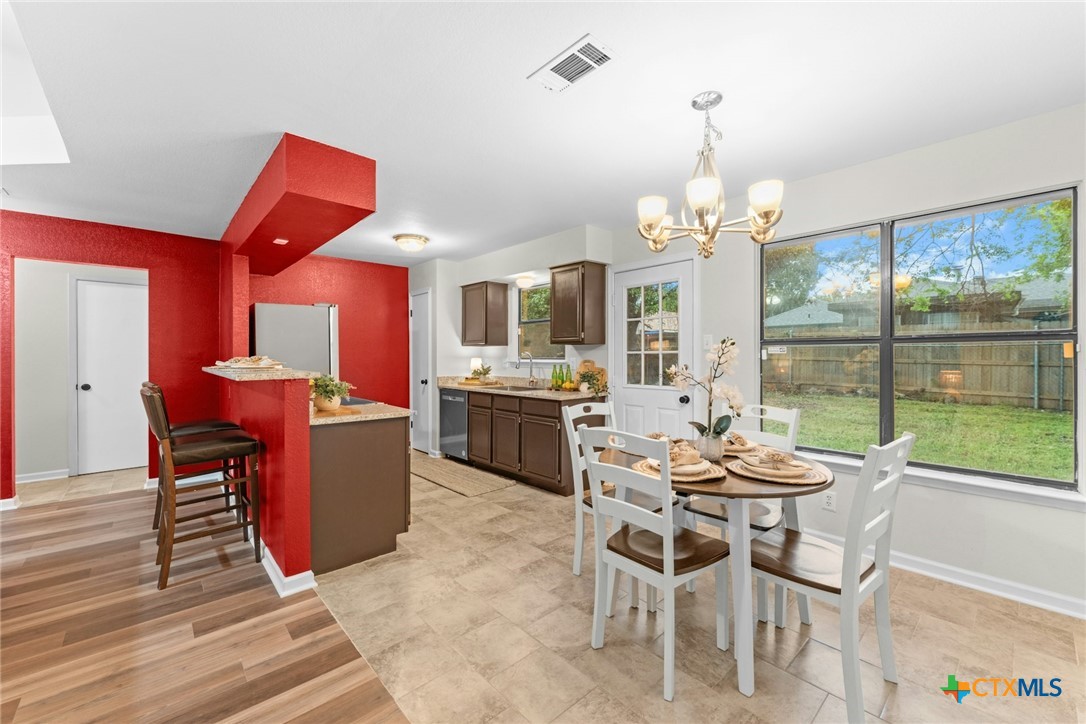 2504 Lazy Ridge Drive Killeen, TX 76543 - Photo 8 of 27 a dining room with wooden floor a chandelier a wooden table and chairs