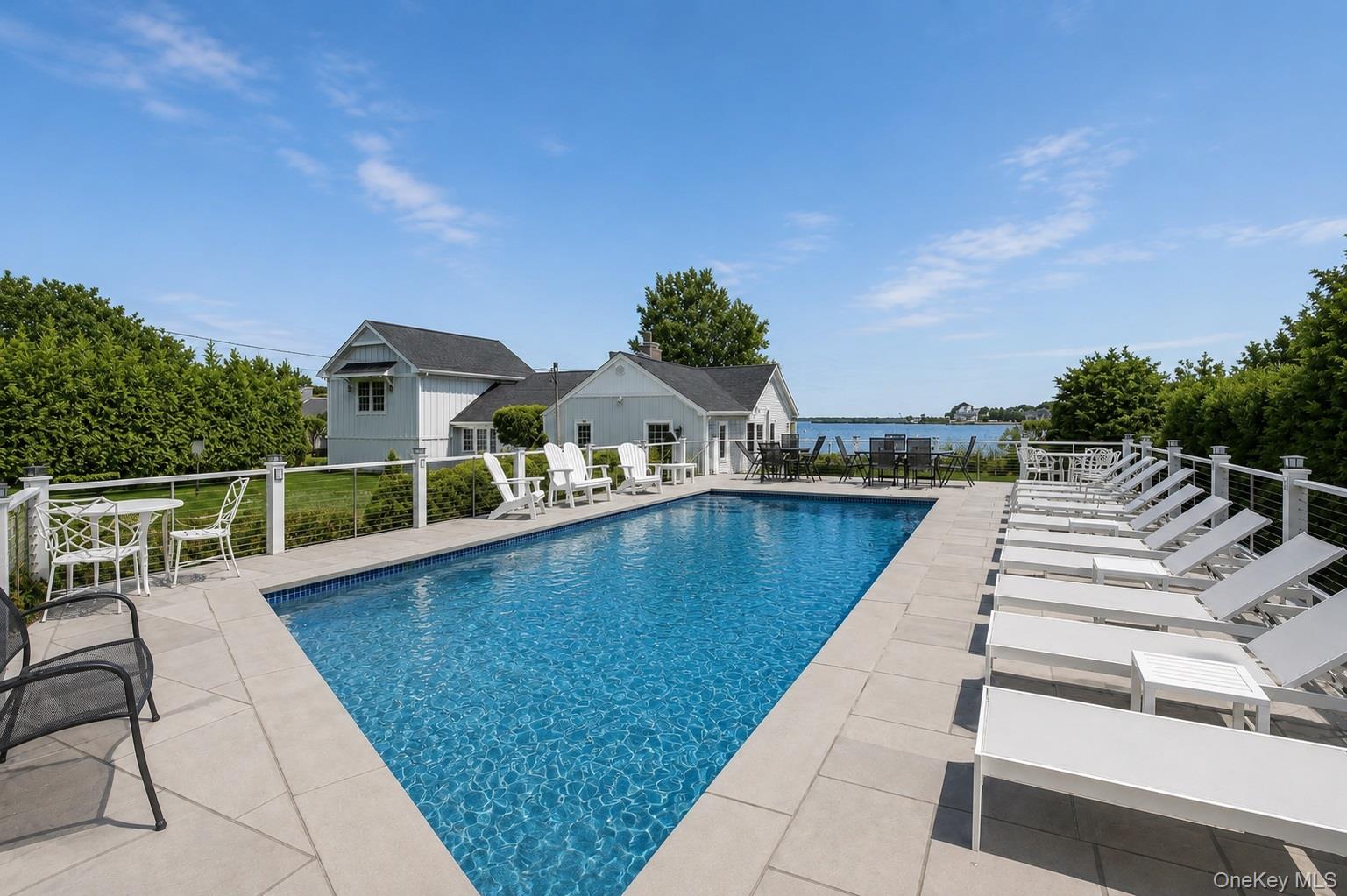 65 Shore Road Westhampton, NY 11977 - Photo 22 of 24 Rectangular in-ground pool surrounded by light-colored paving stones