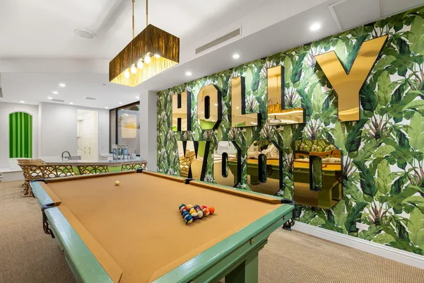 a room with pool table and windows