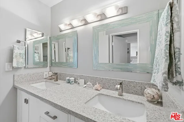 a bathroom with a granite countertop sink double and a mirror