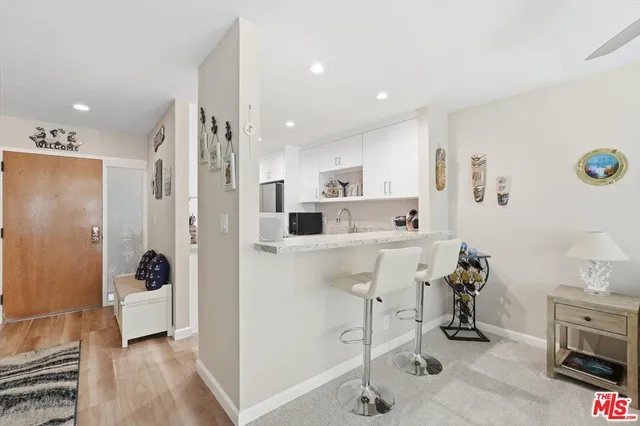 a view of kitchen with stainless steel appliances kitchen island refrigerator stove and cabinets