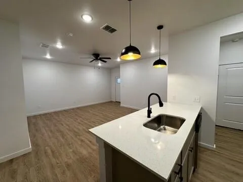 a kitchen with kitchen island a sink stainless steel appliances and living room view