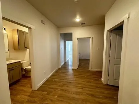 a view of a hallway with wooden floor