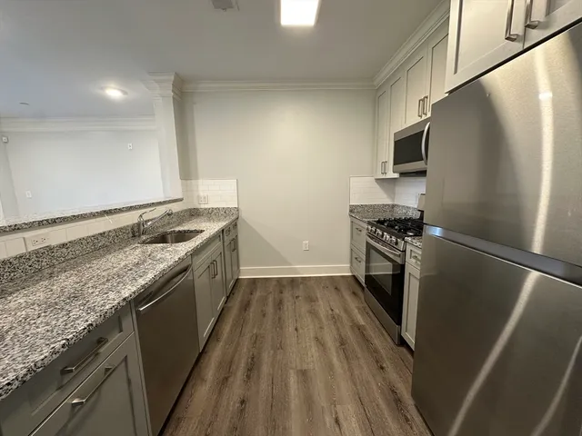 a kitchen with stainless steel appliances granite countertop a stove a refrigerator and a sink