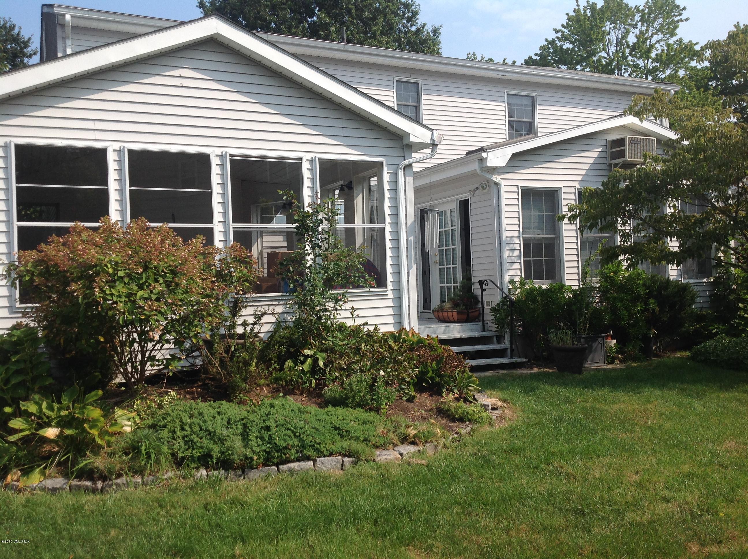 6 Griffith Road Riverside, CT 06878 - Photo 6 of 24 a view of a white house next to a yard and potted plants