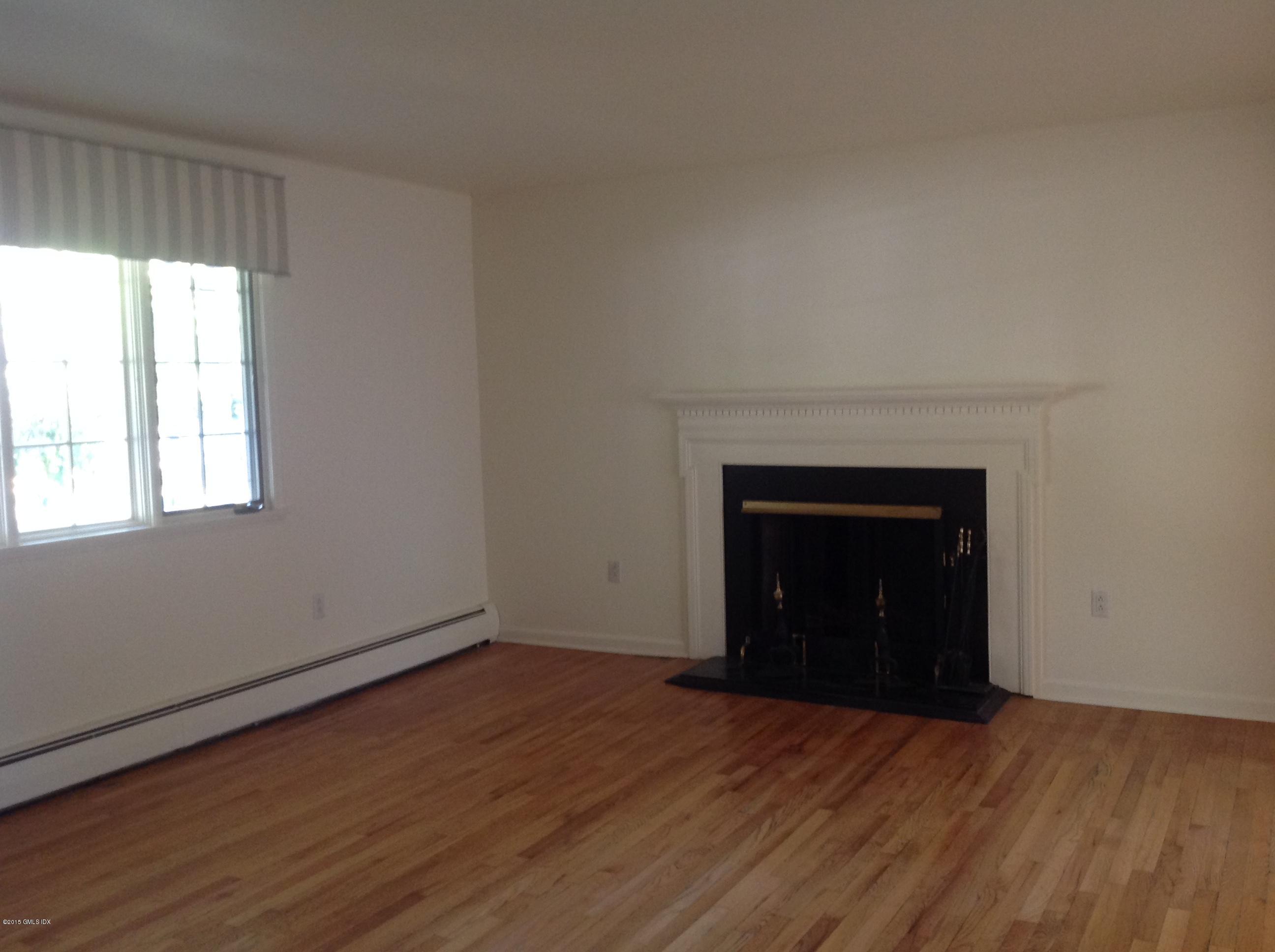 6 Griffith Road Riverside, CT 06878 - Photo 9 of 24 an empty room with a fireplace and wooden floor