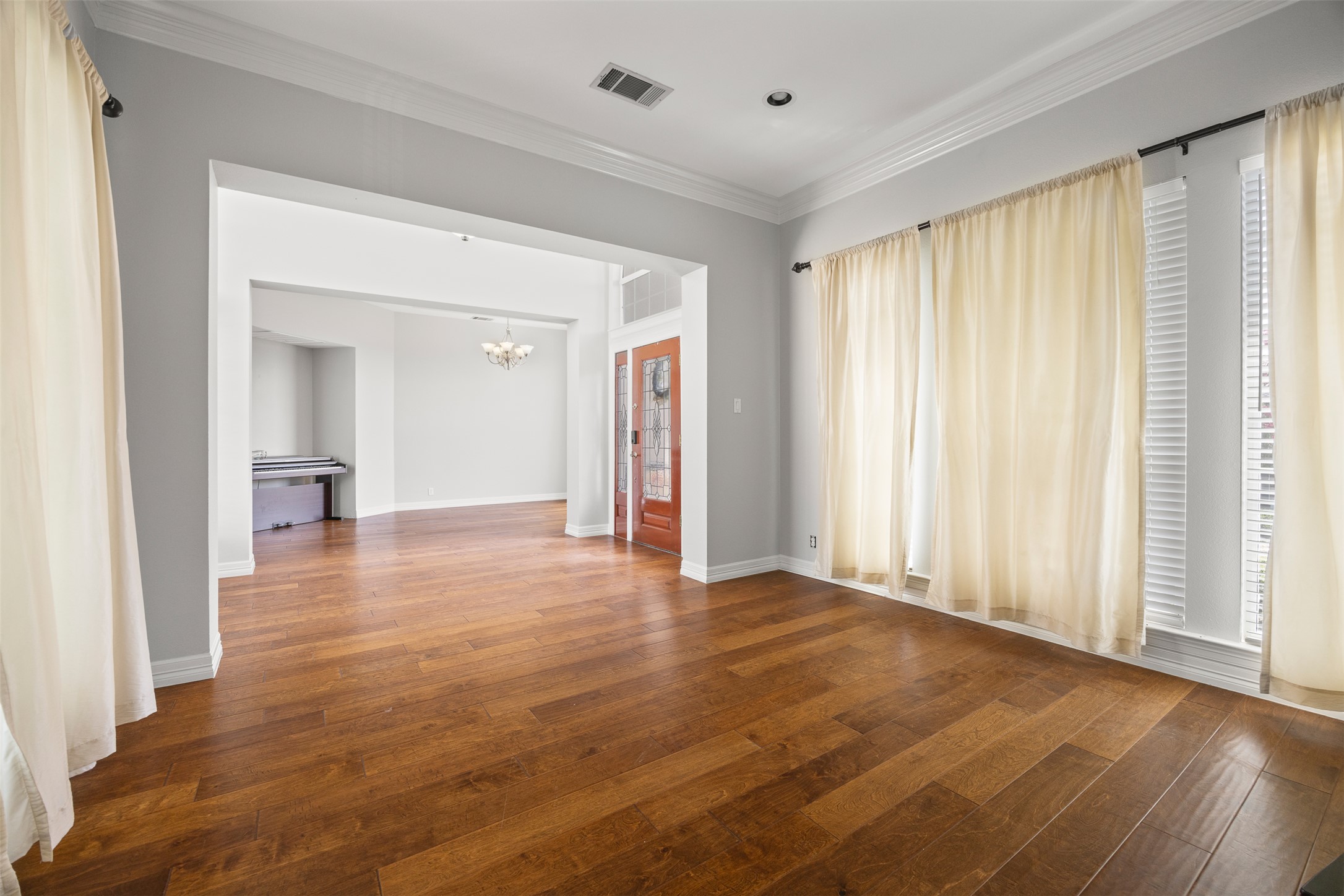 Rich hardwood floors flow through this luminous living space, offering an elegant entry into the home's open layout.