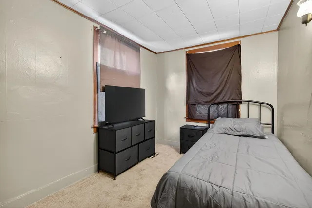 a bedroom with a bed and flat screen tv
