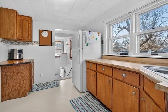a hallway with cabinets a window and a wooden floor