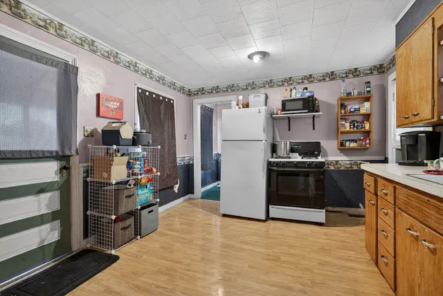 a kitchen with stainless steel appliances a stove refrigerator and cabinets