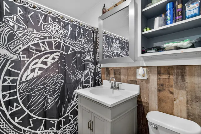 a bathroom with a sink and mirror with toilet