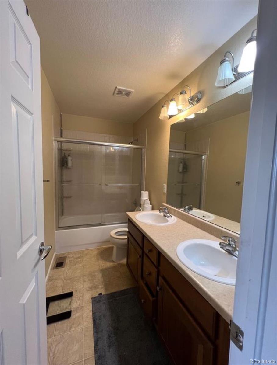 10847 Towerbridge Road Highlands Ranch, CO 80130 - Photo 11 of 14 a bathroom with a sink double vanity granite tub shower and a mirror