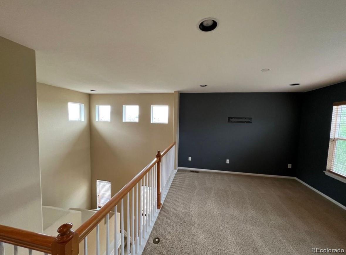 10847 Towerbridge Road Highlands Ranch, CO 80130 - Photo 13 of 14 a view of an empty room with wooden floor and windows
