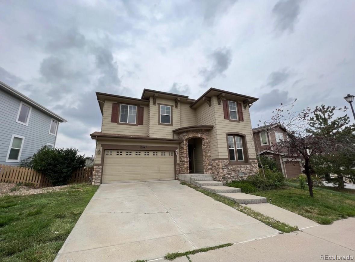 10847 Towerbridge Road Highlands Ranch, CO 80130 - Photo 2 of 14 a front view of a house with a yard and garage