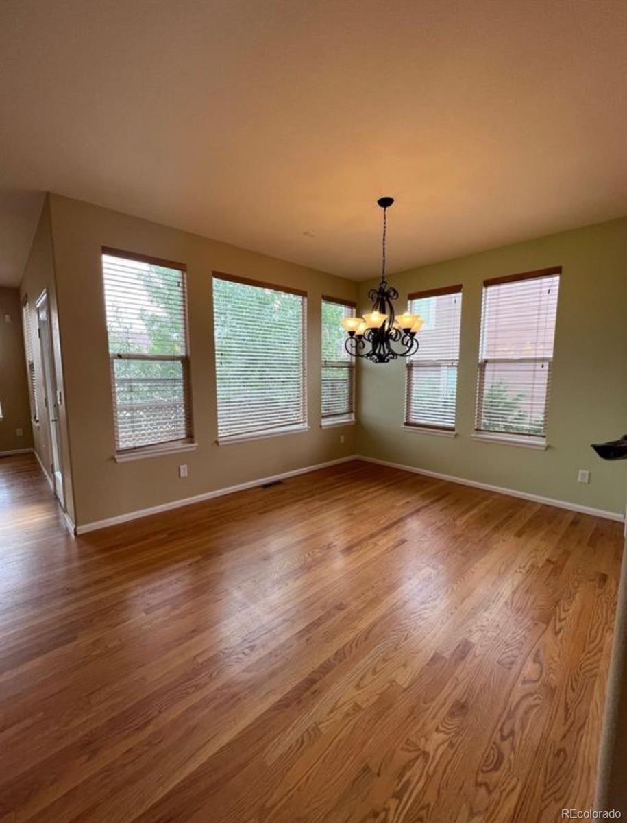 10847 Towerbridge Road Highlands Ranch, CO 80130 - Photo 6 of 14 an empty room with wooden floor and windows