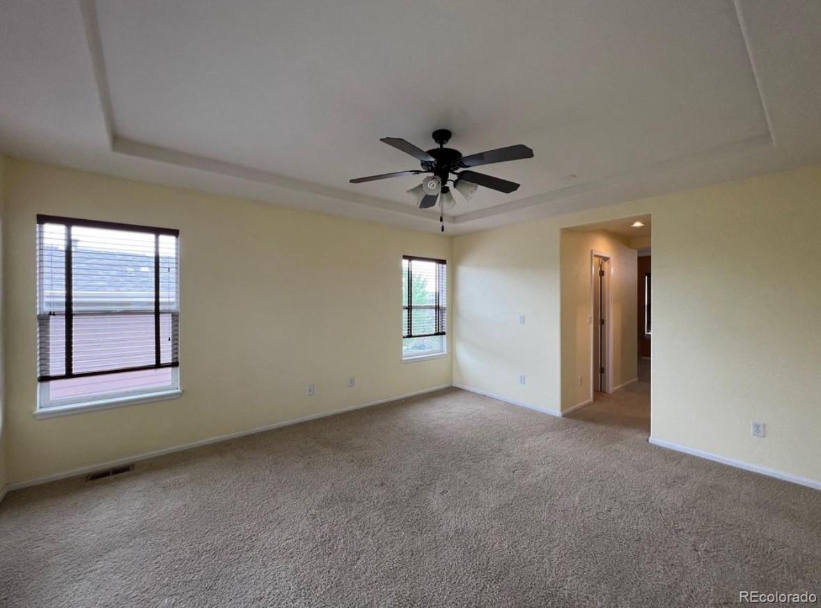 10847 Towerbridge Road Highlands Ranch, CO 80130 - Photo 7 of 14 an empty room with chandelier fan and windows