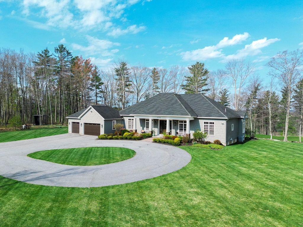 a view of a house with a big yard and large trees