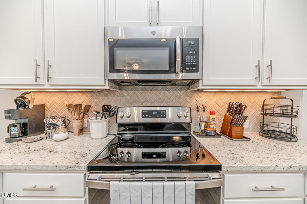 22 Camille Brooks Drive Angier, NC 27501 - Photo 19 of 52 a kitchen with granite countertop a stove and cabinets