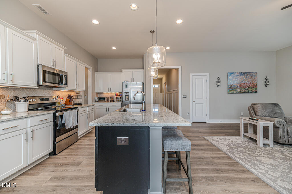 22 Camille Brooks Drive Angier, NC 27501 - Photo 21 of 52 a kitchen with stainless steel appliances granite countertop a sink stove and refrigerator