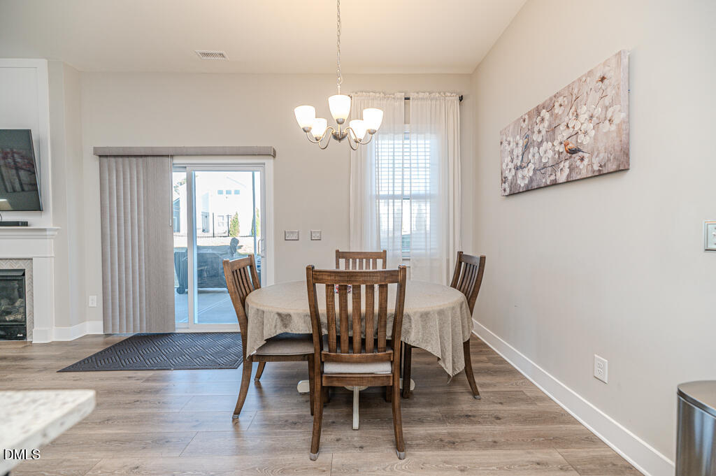 22 Camille Brooks Drive Angier, NC 27501 - Photo 25 of 52 a view of a dining room with furniture a chandelier and wooden floor